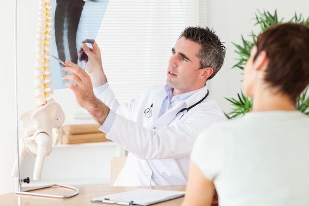 Le médecin montre les dommages causés à la colonne vertébrale par l'ostéochondrose cervicale